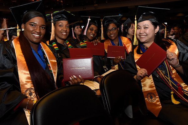 graduates posing with degree