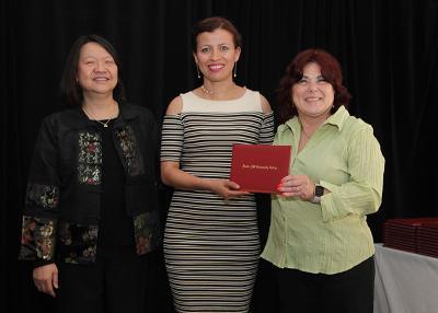 female student receives diploma from Toni and president eddinger 