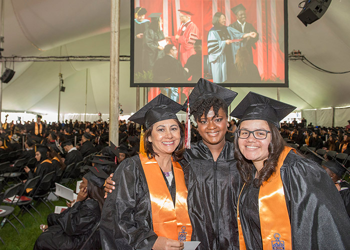 three female student posing in graduation robes
