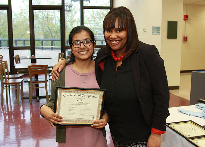 Student posing with certificate with Latoya Robinson 