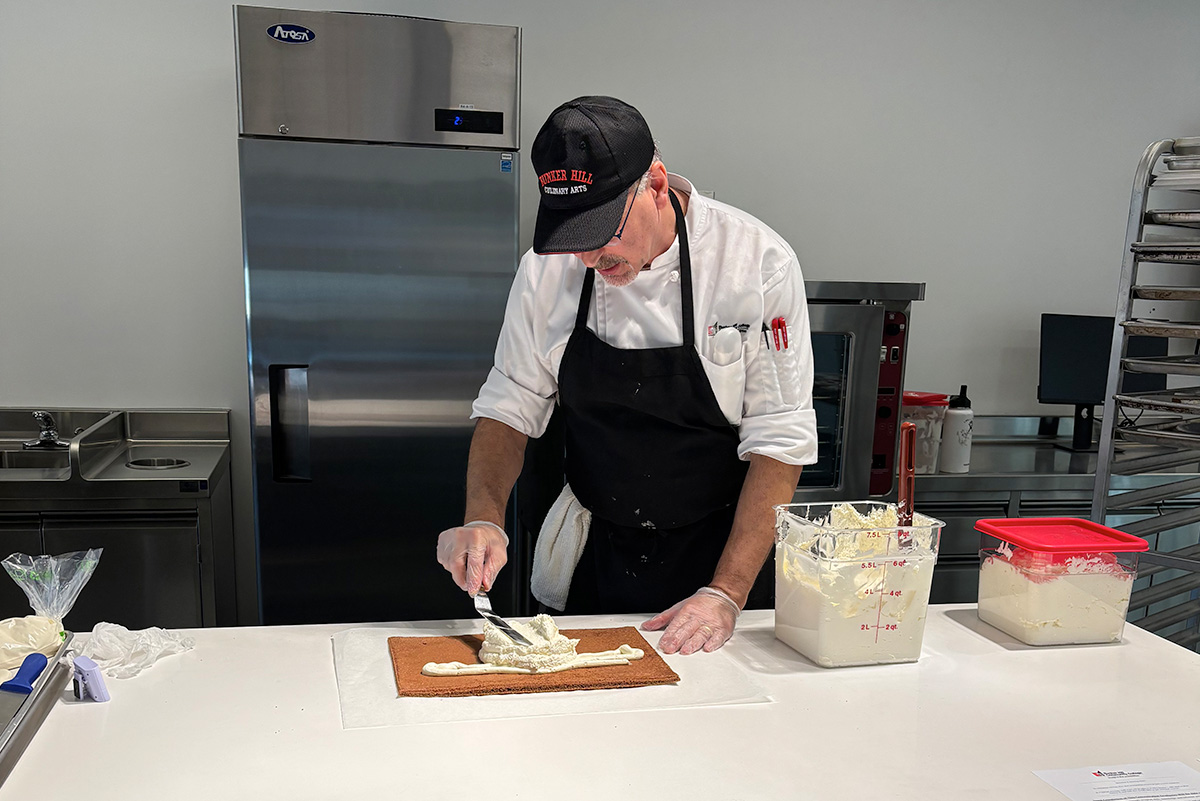 chef frosting a cake
