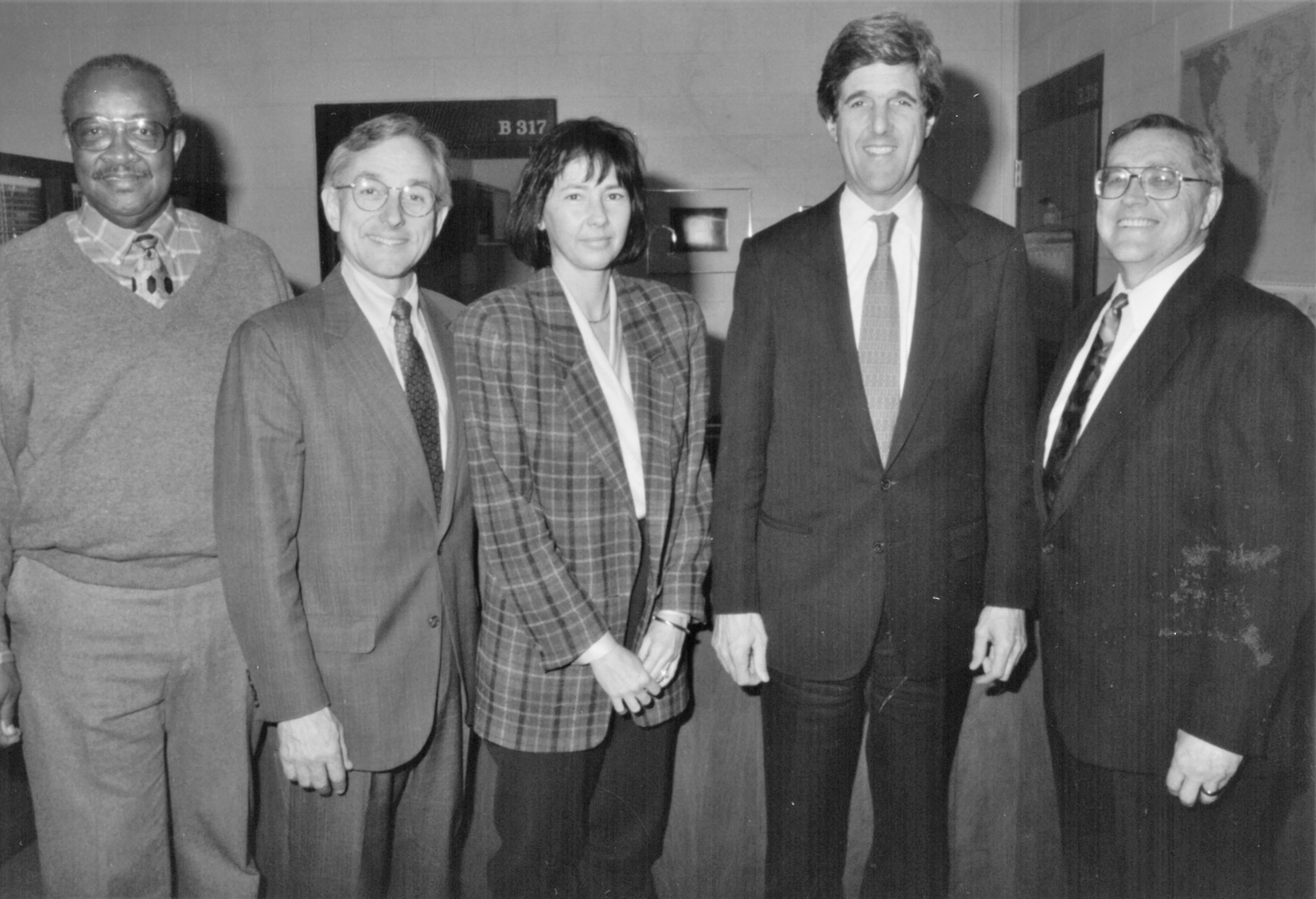 Kerry_O'Shea96.jpg - Black and white photograph of Senator Kerry with Anne Hyde, President O'Shea, and other BHCC staff