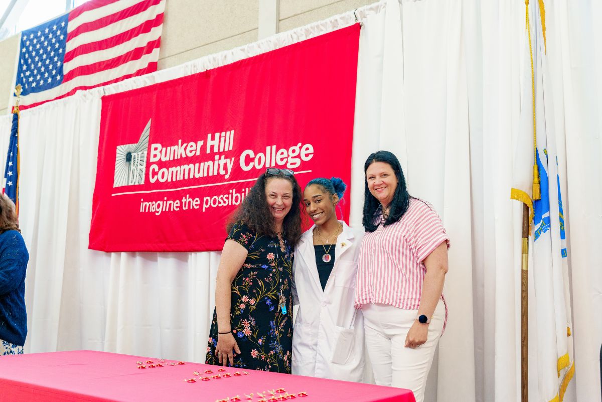 Student posing after pinning with faculty