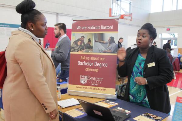 admissions talking with a student at a college fair