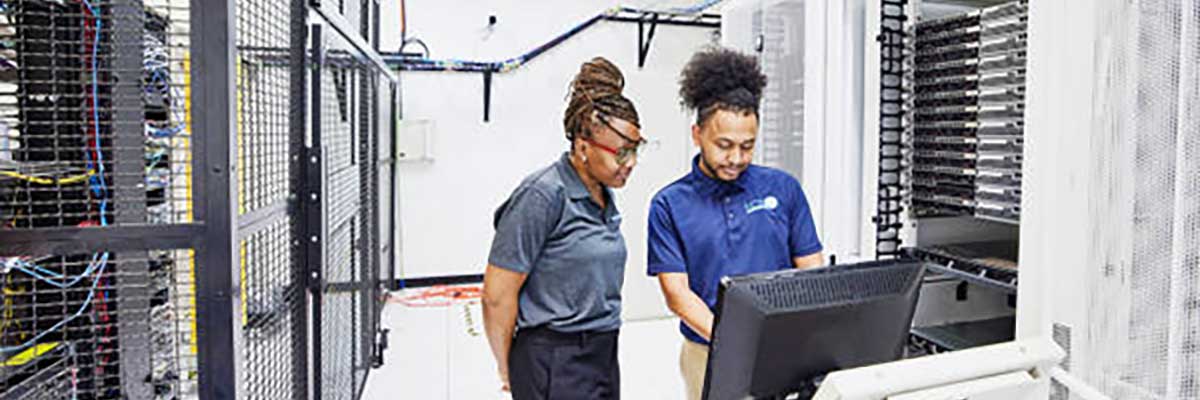 Two IT support people in a server room.